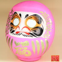良縁祈願の開運グッズであるピンクの高崎だるま：左斜め前画像
